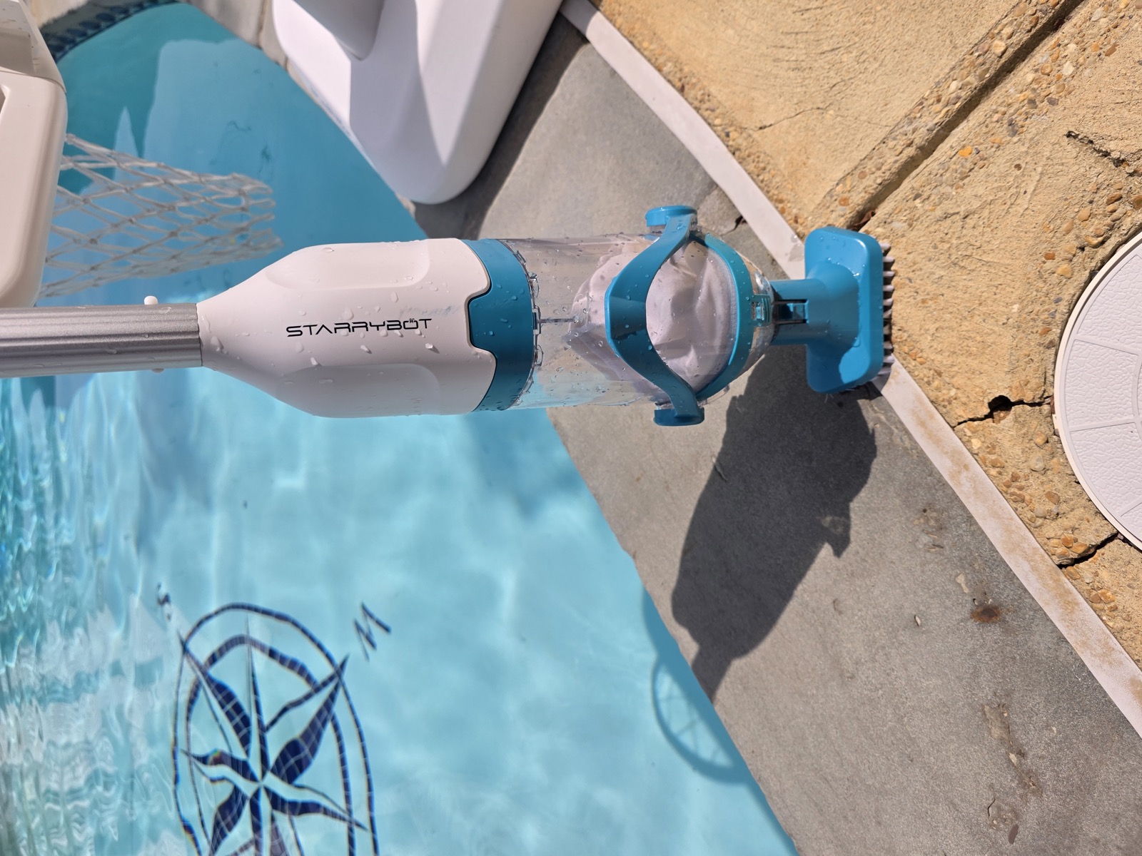 Starrybot standing on pool coping, wet blue head on compass mosaic