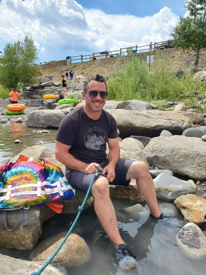 Mr. Questionable sitting on a rock in a river